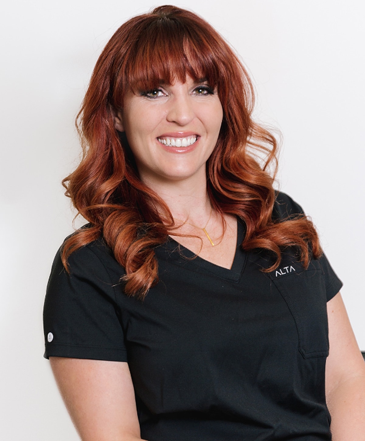 Smiling woman in a black medical uniform.