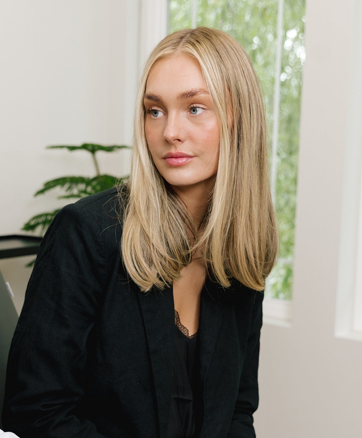 Woman with long blonde hair in black blazer.