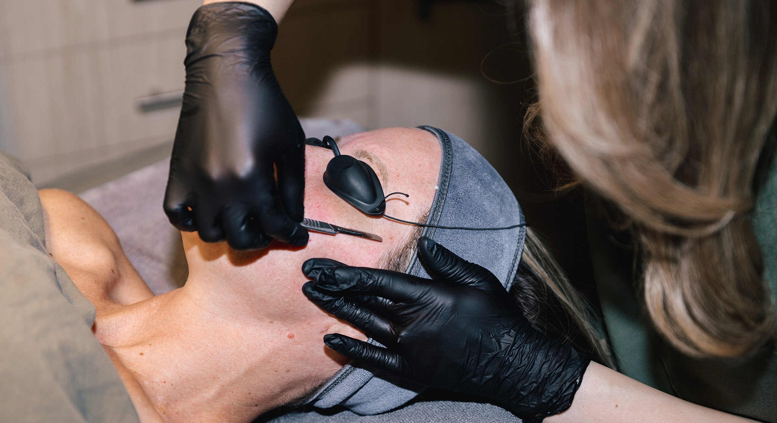 Salt Lake City dermaplaning model receiving facial treatment in spa.