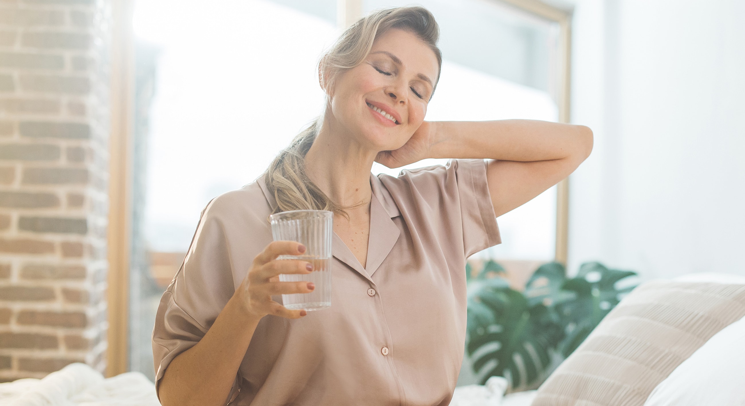 Woman relaxing at home with a glass of water.