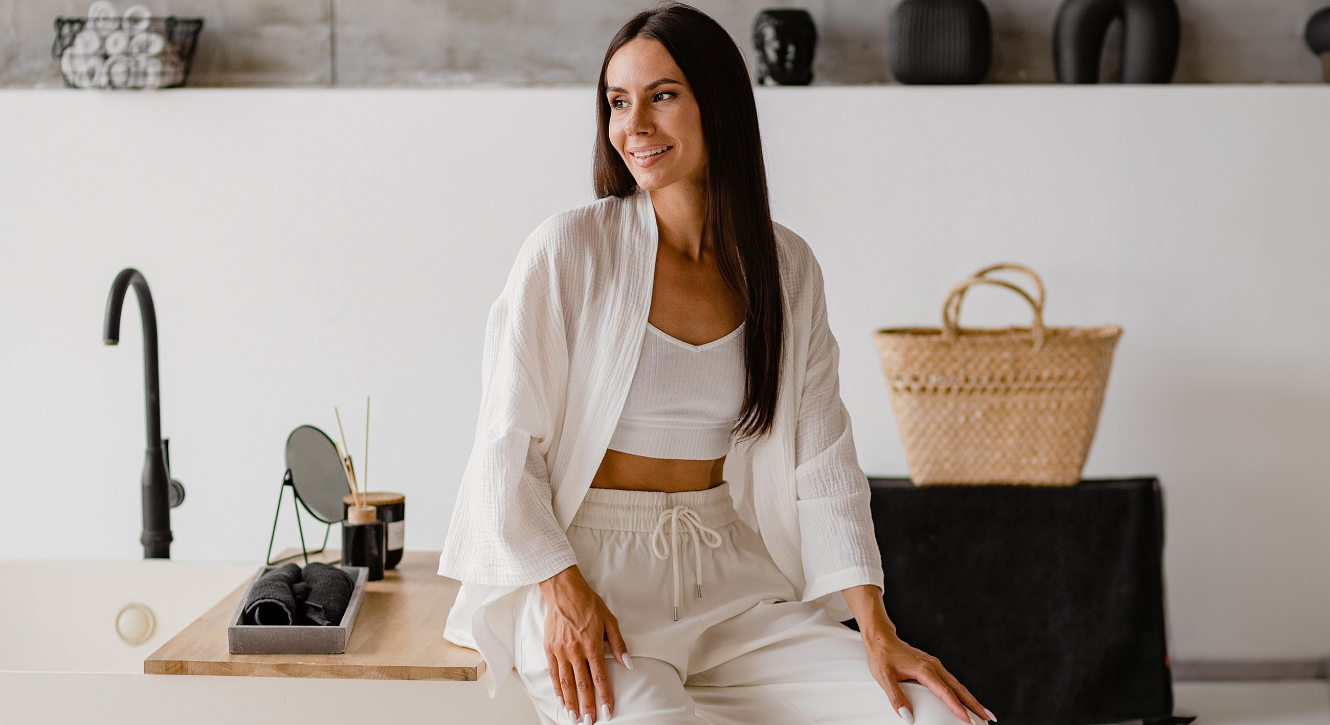 Woman in stylish white outfit, natural setting.