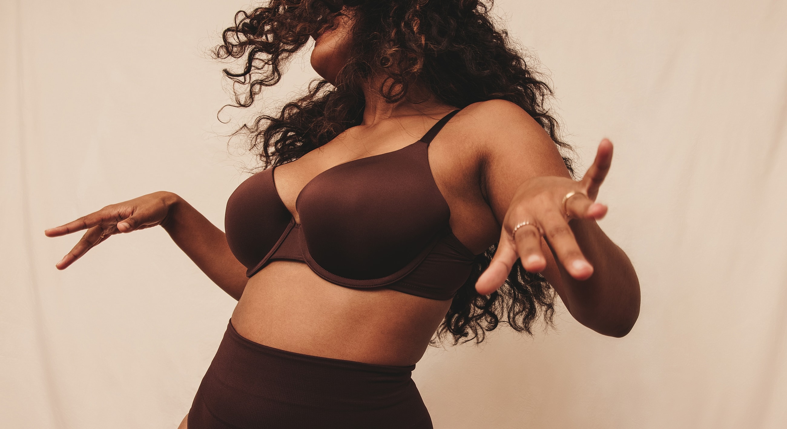 Model in brown lingerie posing with confidence.