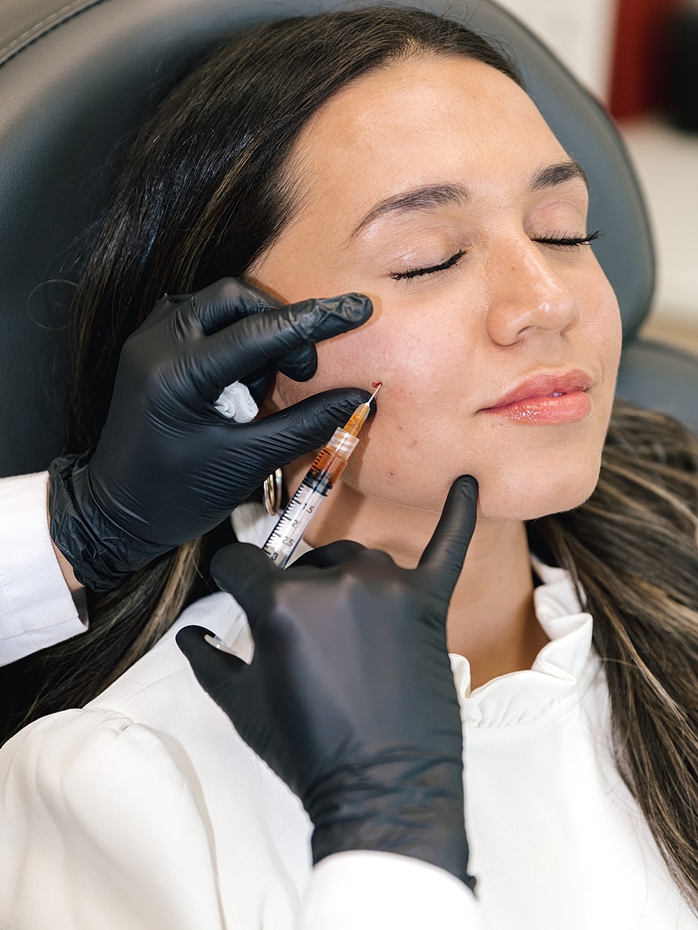 Woman receiving lip treatment in a clinic.